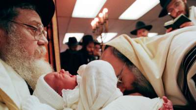 bebê sendo circuncidado por rabinos